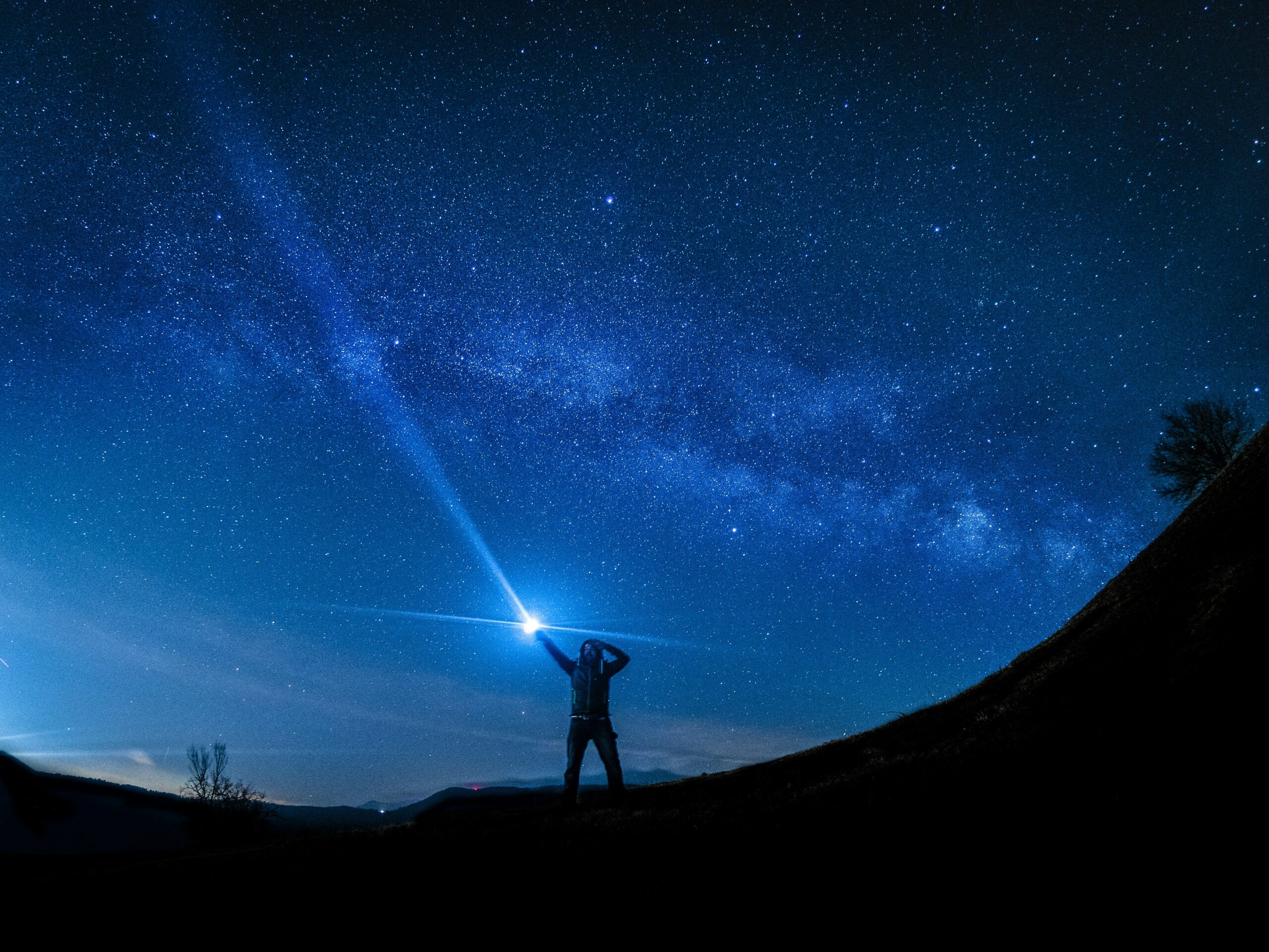 silhouette of man holding flashlight